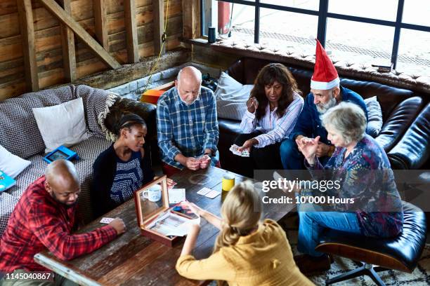 family playing games on coffee table at christmas - hythe stock-fotos und bilder