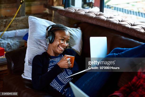 Young woman wearing headphones on laptop video call