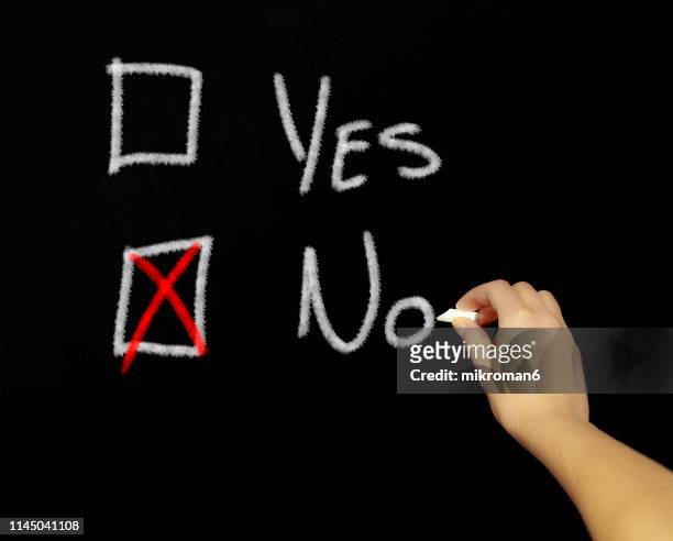 hand drawing a tick the box question are with chalk in black board - chalk x stock-fotos und bilder