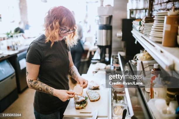 frau arbeitet im cafe bereitet sandwiches zu - woman sandwich stock-fotos und bilder