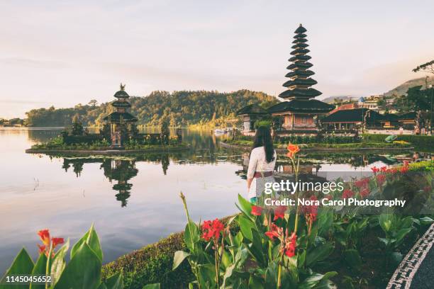 young balinese woman looking at the view in pura ulun danu bratan - pura ulu danau temple stock pictures, royalty-free photos & images