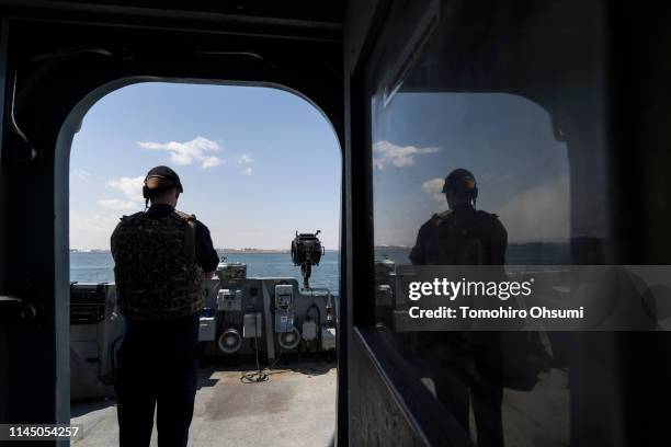 British Royal Navy member stands guard on board the HMS Montrose frigate as it sails to a joint exercise with Japanese Maritime Self-Defense Force...