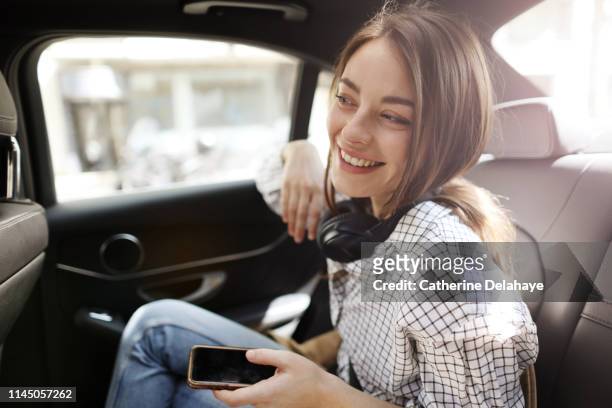 portrait of a young woman in a parisian taxi - rücksitz stock-fotos und bilder