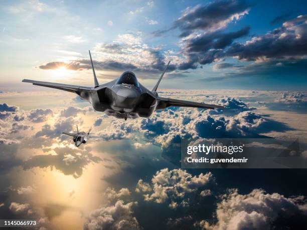 f-35 fighter jets fliegen bei sonnenuntergang über den wolken - jagdflugzeug stock-fotos und bilder