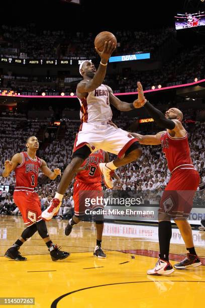 LeBron James of the Miami Heat drives for a shot attempt against Carlos Boozer and Derrick Rose of the Chicago Bulls in Game Three of the Eastern...