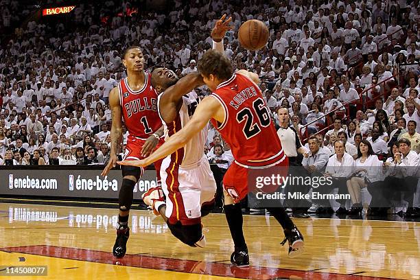 Dwyane Wade of the Miami Heat loses the ball as he drives against Kyle Korver and Derrick Rose of the Chicago Bulls in Game Three of the Eastern...