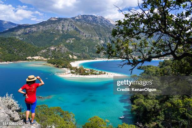 woman facing the beach. ölüdeniz from fethiye, turkey. - caria stock pictures, royalty-free photos & images