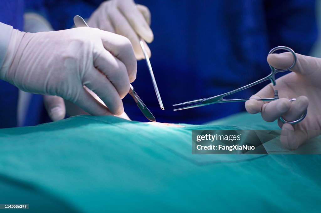 Mãos dos doutores que executam a cirurgia no quarto de funcionamento do hospital