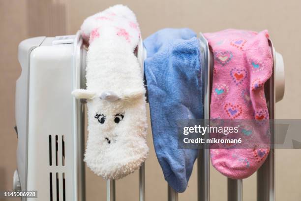 socks drying on electric heater convector at home. - electric heater stock pictures, royalty-free photos & images