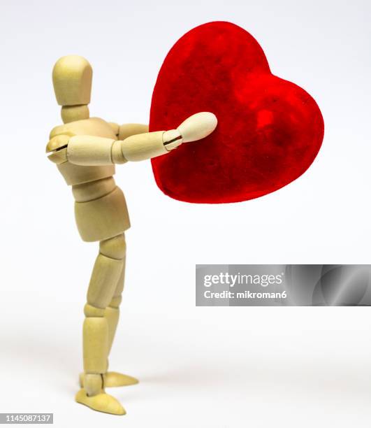 mannequin holding a red heart - doll imagens e fotografias de stock