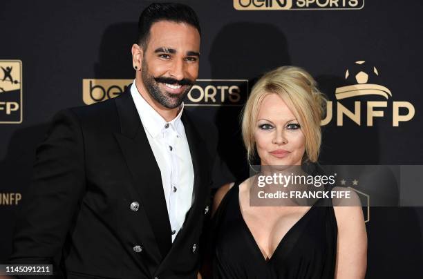 Marseille's defender Adil Rami and US actress Pamela Anderson arrive to take part in a TV show on May 19, 2019 in Paris, as part of the 28th edition...