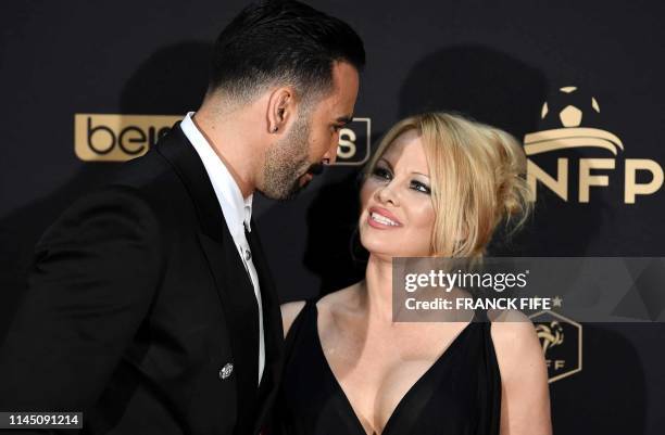 Marseille's defender Adil Rami and US actress Pamela Anderson arrive to take part in a TV show on May 19, 2019 in Paris, as part of the 28th edition...