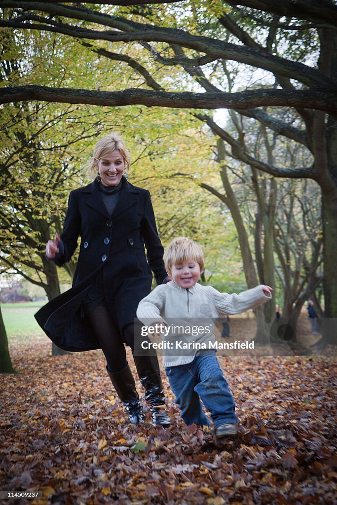 Woman and boy running in park