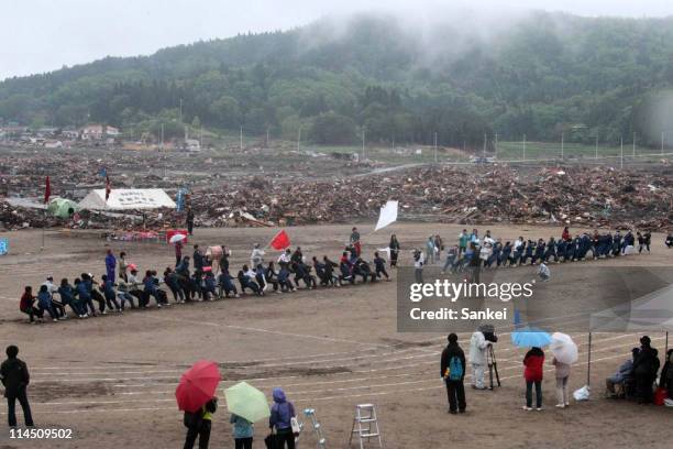 Otomo Junior High School students compete during the athletic meets held at debris-cleared Otomo Elementary School on May 22, 2011 in Rikuzentakata,...