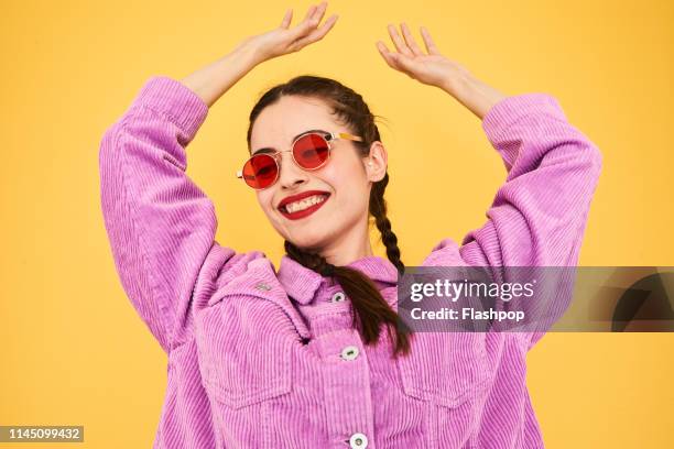 colourful studio portrait of a young woman - sunglasses stock-fotos und bilder