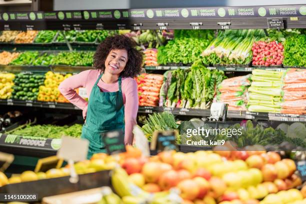 young african-american woman working in grocery store - secção de frutas e legumes imagens e fotografias de stock