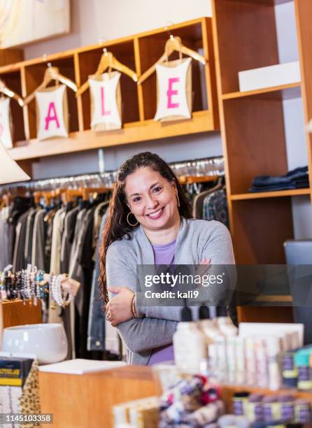 hispanic woman working in boutique - retail sales agent stock pictures, royalty-free photos & images