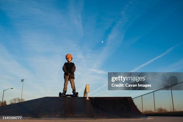 young boy on top of pyramid ramp on his hover board at skate park - hoverboard - fotografias e filmes do acervo