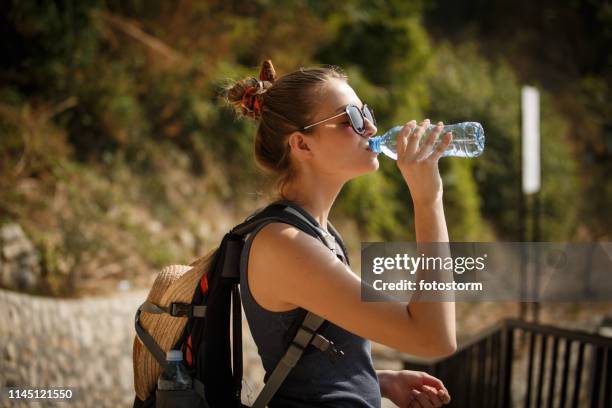 female hiker drinking water - holding sunglasses stock pictures, royalty-free photos & images