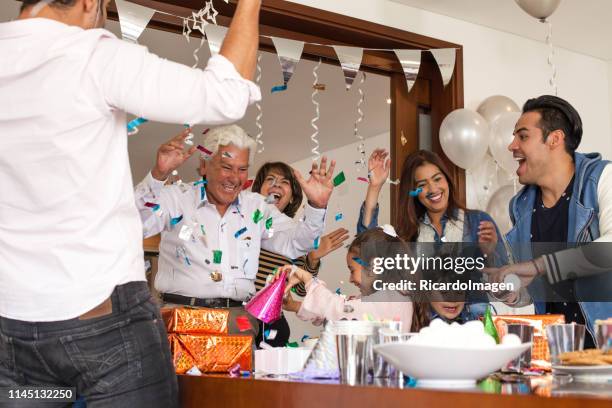 latin family celebrating grandfather´s birthday all together, in the picture appear grandparents, parents and grandchildren - man giving cake candle stock pictures, royalty-free photos & images