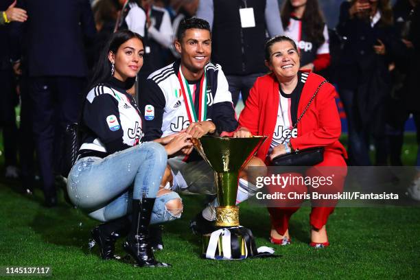 Cristiano Ronaldo of Juventus poses with the Serie A trophy alongside his girlfriend Georgina Rodríguez and mother Maria Dolores dos Santos Aveiro...