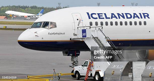 An SAS Boeing 737 aircraft takes off behind a stranded Iceland Air Boeing 757 aircraft, named after the Eyjafjoell volcano, at Arlanda airport north...