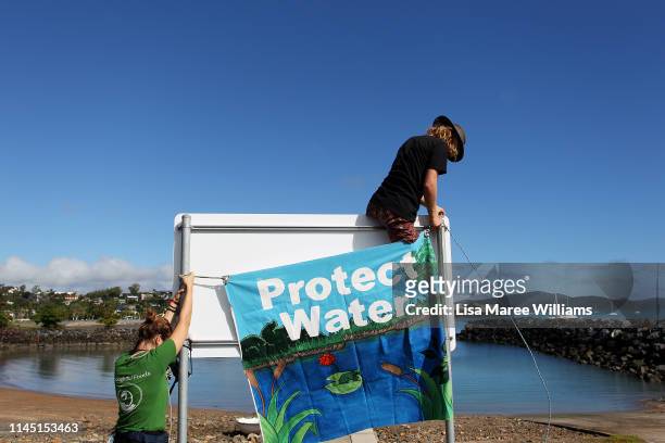 Environment activists put up a sign at the edge of Airlie Bay ahead of a anti Adani Carmichael Coal Mine rally on April 26, 2019 in Airlie Beach,...