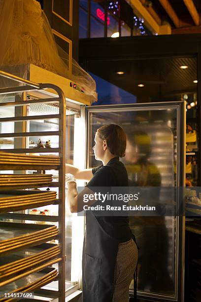 chef places pastries in refrigerator - short-order-cook stock pictures, royalty-free photos & images