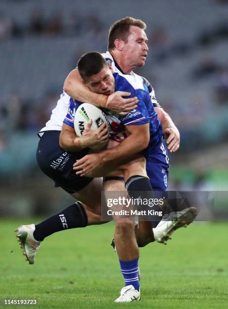 Jack Cogger of the Bulldogs is tackled by Michael Morgan of the Cowboys during the round 7 NRL match between the Canterbury Bulldogs and the North...