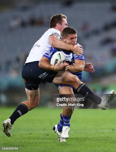 Jack Cogger of the Bulldogs is tackled by Michael Morgan of the Cowboys during the round 7 NRL match between the Canterbury Bulldogs and the North...
