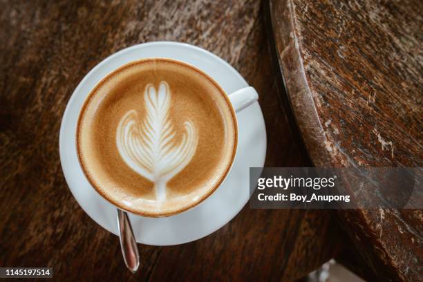 a cup of hot latte coffee on the wooden table. high angle view. - coffee cup top view stock pictures, royalty-free photos & images