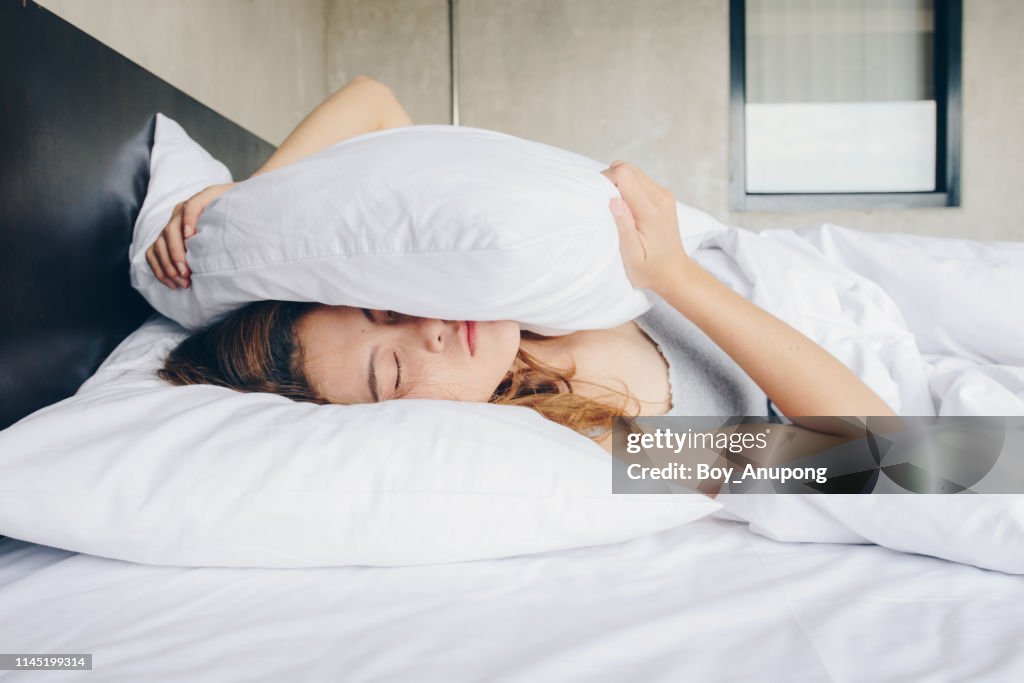 Young beautiful Asian woman hates waking up early in the morning.