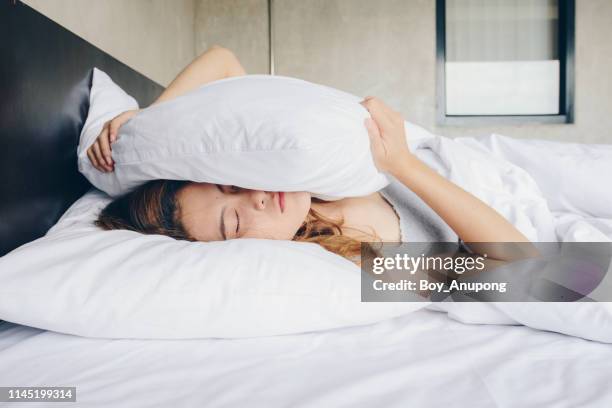 young beautiful asian woman hates waking up early in the morning. - girl in her bed stock pictures, royalty-free photos & images