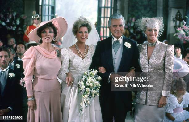 Stars of television soap opera "Dynasty" pose for photo during filming of wedding scene location in Hollywood Los Angeles california USA circa 1985: