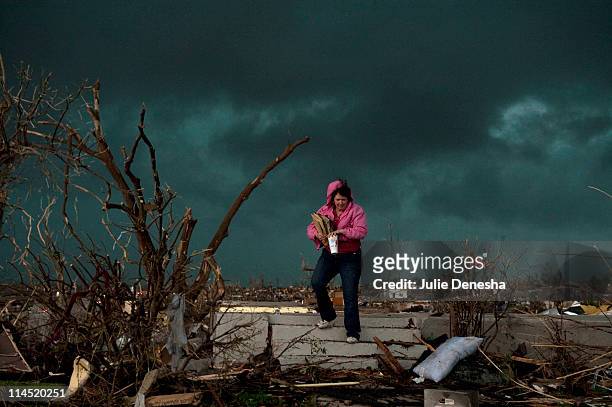 Janet Martin attempts to salvage medication and mementos from her brother's home before a second storm moves in, on May 23, 2011 in Joplin, Missouri....