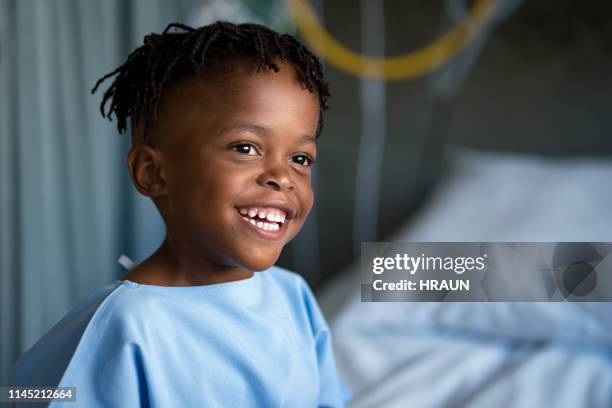 lächelnde junge schaut weg in kinderkrankenhaus - child in hospital stock-fotos und bilder