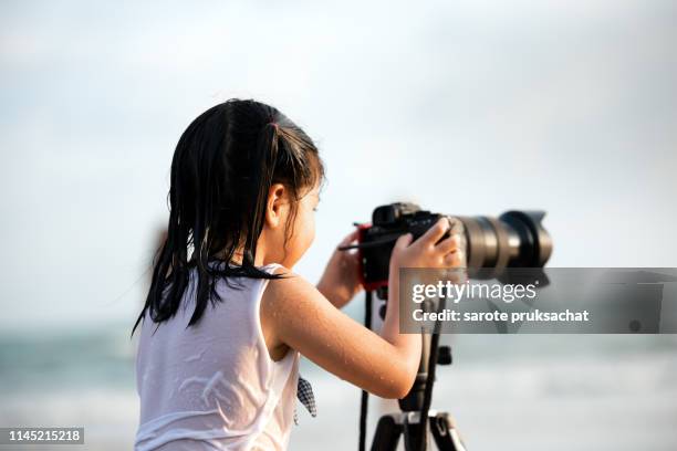 cute asian girl with digital camera beach side area. - cam girl stock pictures, royalty-free photos & images