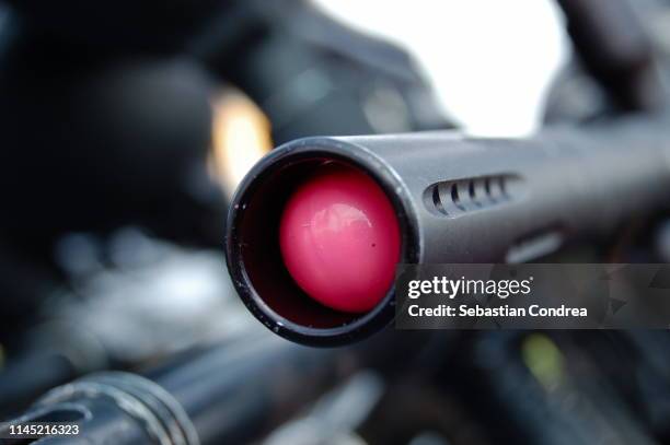 paintball gun with pink ball splash. - paintball stock pictures, royalty-free photos & images
