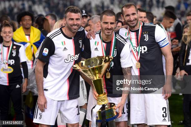 Andrea Barzagli , Leonardo Bonucci and Giorgio Chiellini of Juventus FC hold the trophy after winning the Serie A Championship 2018-2019 at the end...