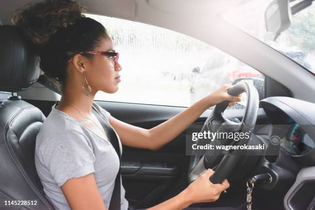 portrait of young woman driving a car - car profile stock pictures, royalty-free photos & images