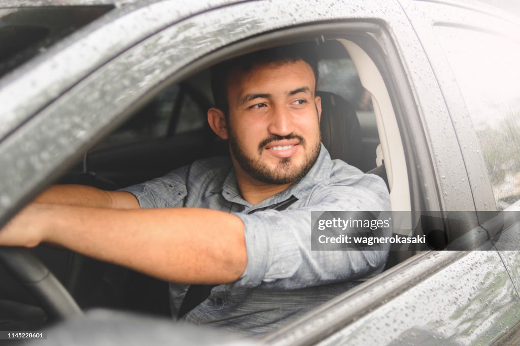 Portrait of brazilian latin guy driving a car
