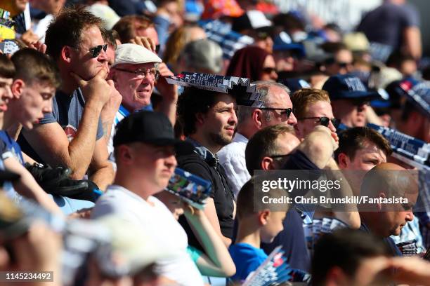 Huddersfield Town fan shields his head from the sun during the Premier League match between Huddersfield Town and Watford FC at John Smith's Stadium...