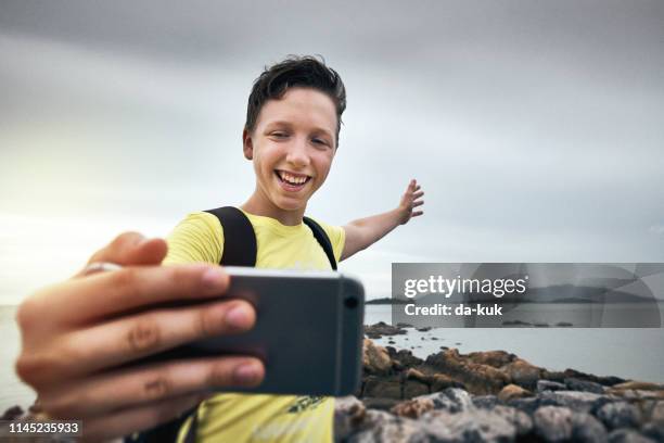taking selfie on rocky beach at vacation - kids filming stock pictures, royalty-free photos & images
