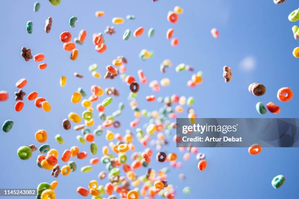 colorful fruit loops cereals levitating in the sky in a beautiful visual effect. - fruit loops stock pictures, royalty-free photos & images