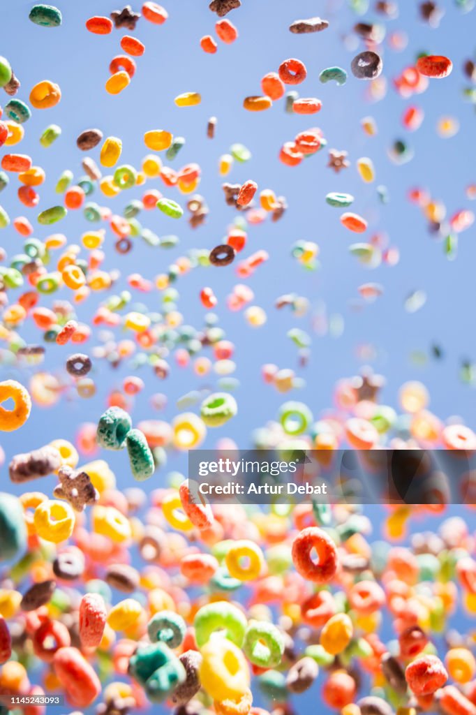 Colorful fruit loops cereals levitating in the sky in a beautiful visual effect.