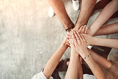 Group of friends stack their hands together, teamwork concept