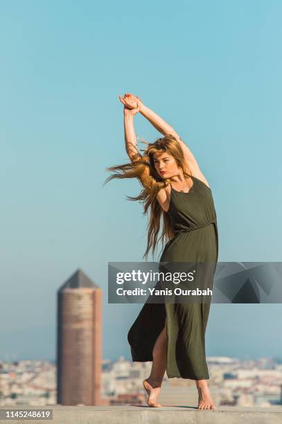 young blond modern dancer dancing in the streets of lyon, france with a panorama of the city in background - donne bionde scalze foto e immagini stock