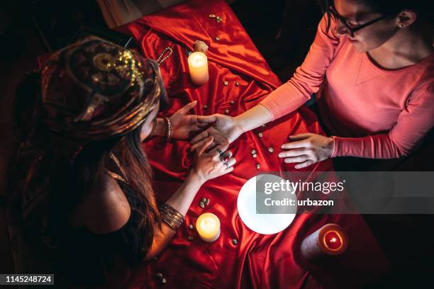 fortune teller reading from palm - fortune teller table stock pictures, royalty-free photos & images