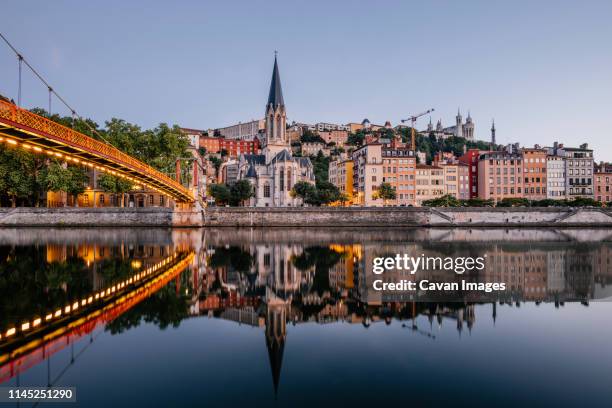 paul-couturier footbridge over saone river against buildings in city during sunset - lyon stock-fotos und bilder