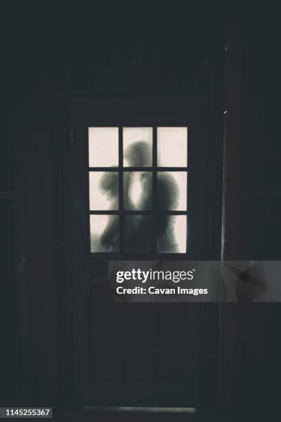 newlywed couple kissing seen through cottage window - embrasser sur la bouche photos et images de collection